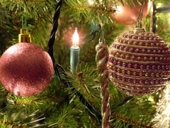 Kerstlampje tussen twee kerstballen in de boom