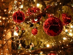 Rode kerstballen tussen de kerstverlichting in de boom
